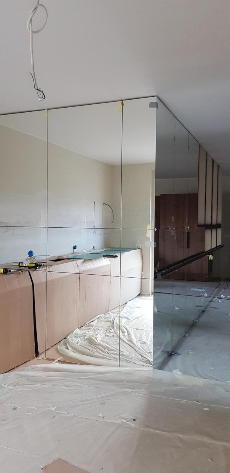 Montaža velike zrcalne stene iz več ogledal v notranjem prostoru